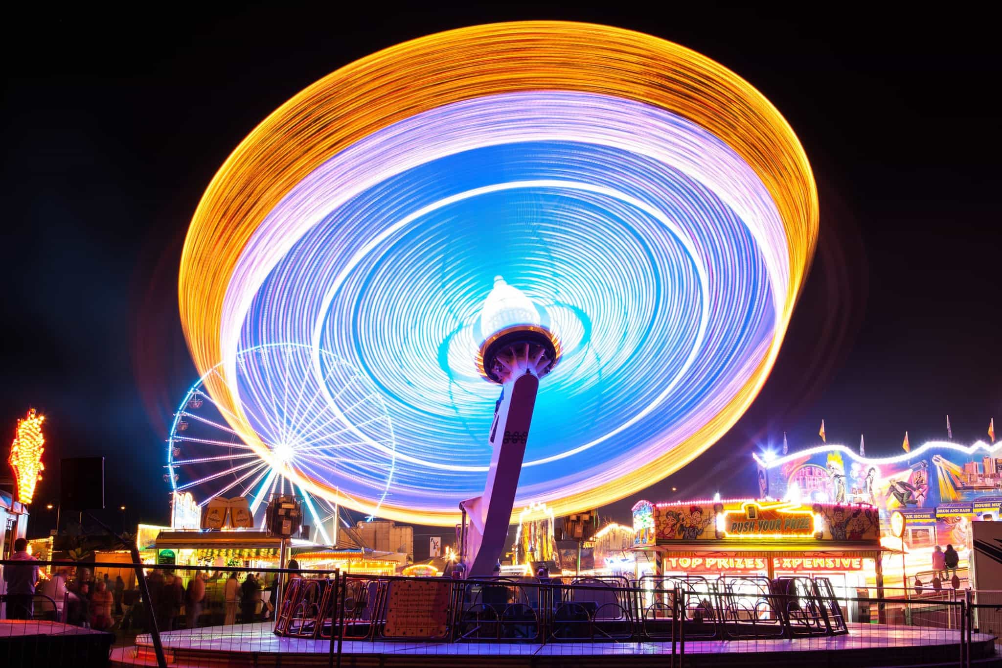 spinning carnival ride lit up at night; roller coaster accidents attorneys, carnival ride accidents