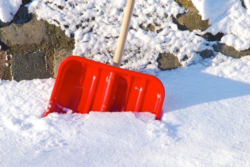 snow shovel halfway in a pile of snow