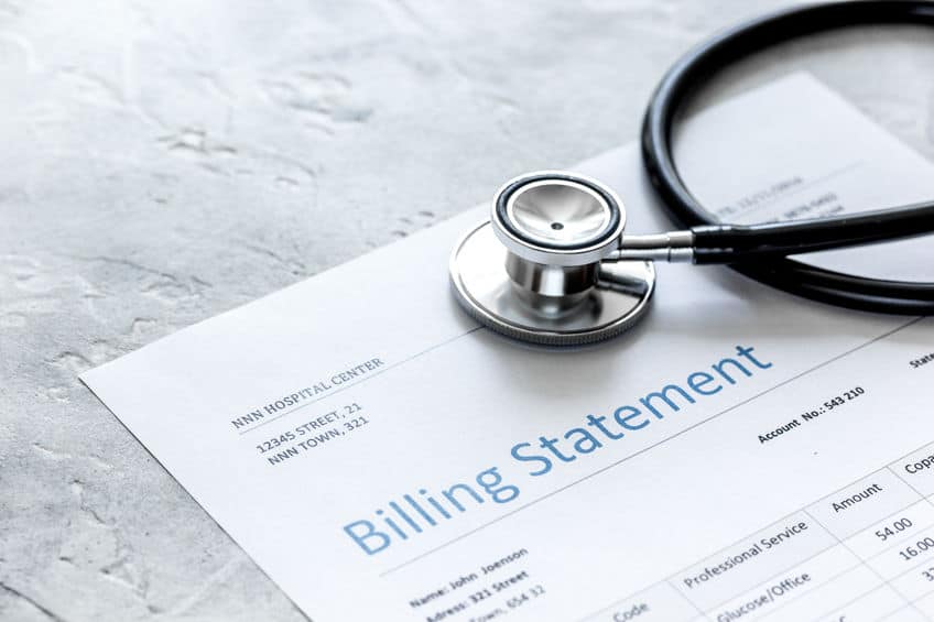 health care costs on a billing statement, stethoscope on stone table background