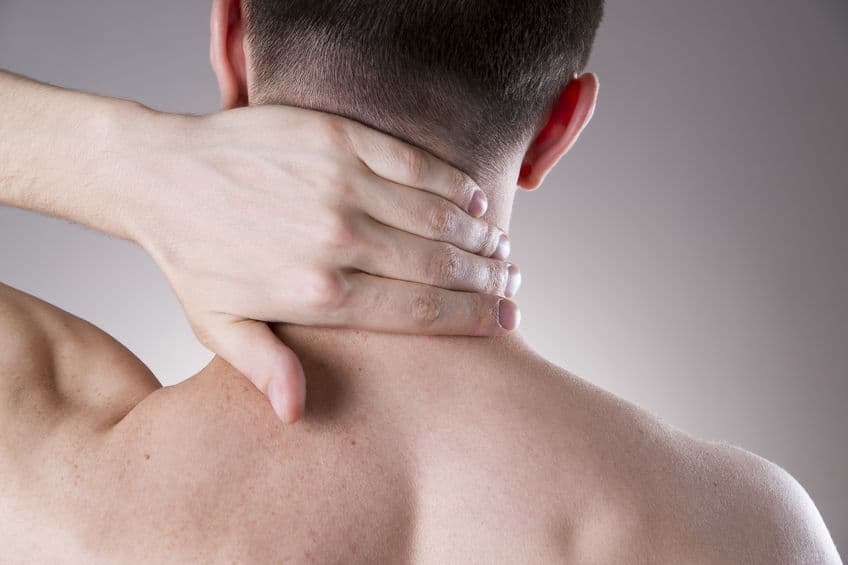 person holding the back of their neck in pain
