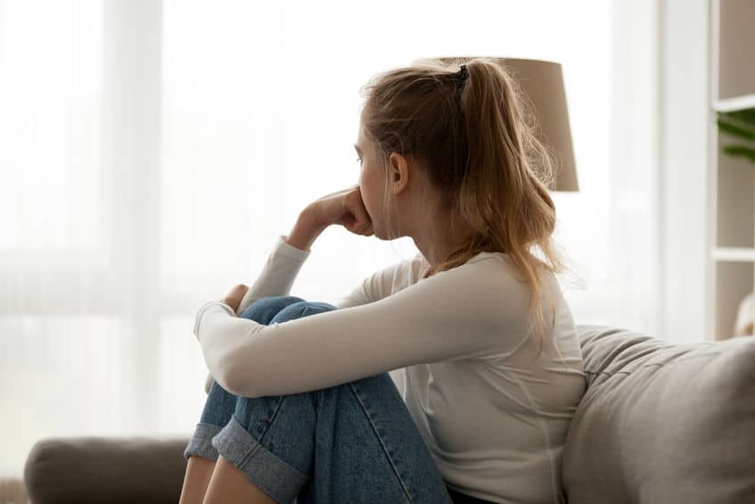 woman sitting on couch looking out the window