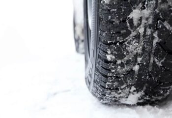 close up of snow tires against a snow covered ground